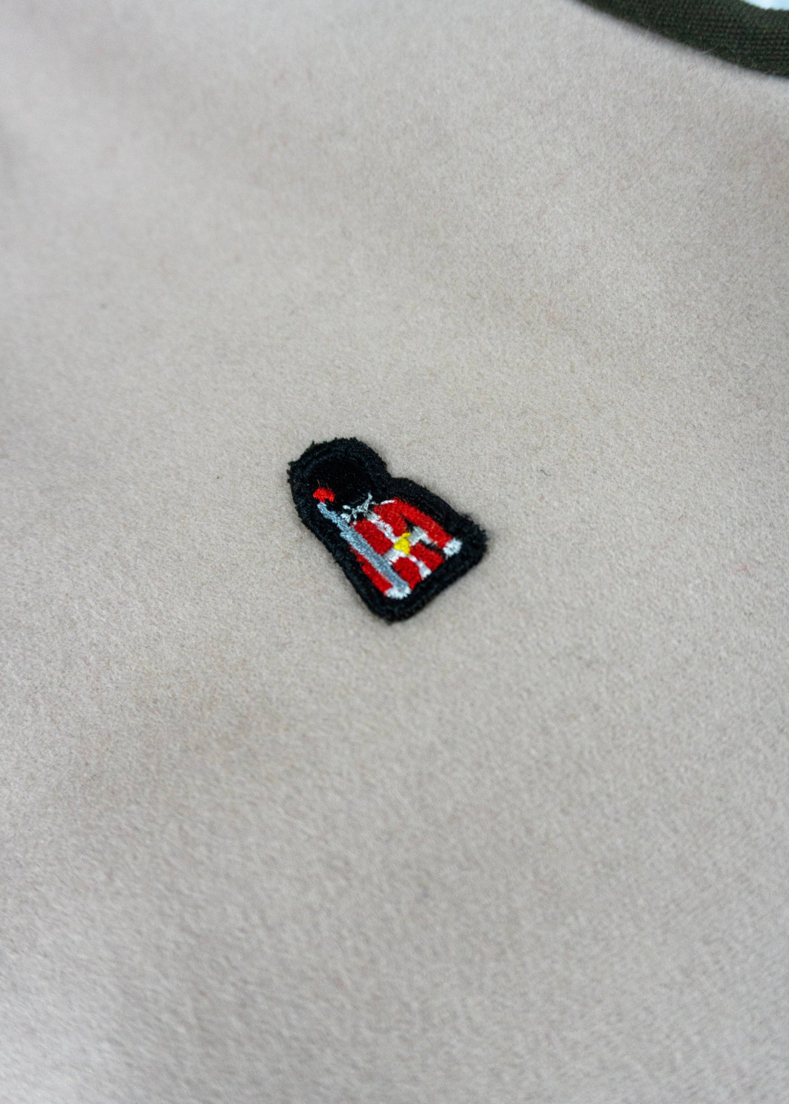 Small embroidered patch on a beige fabric background