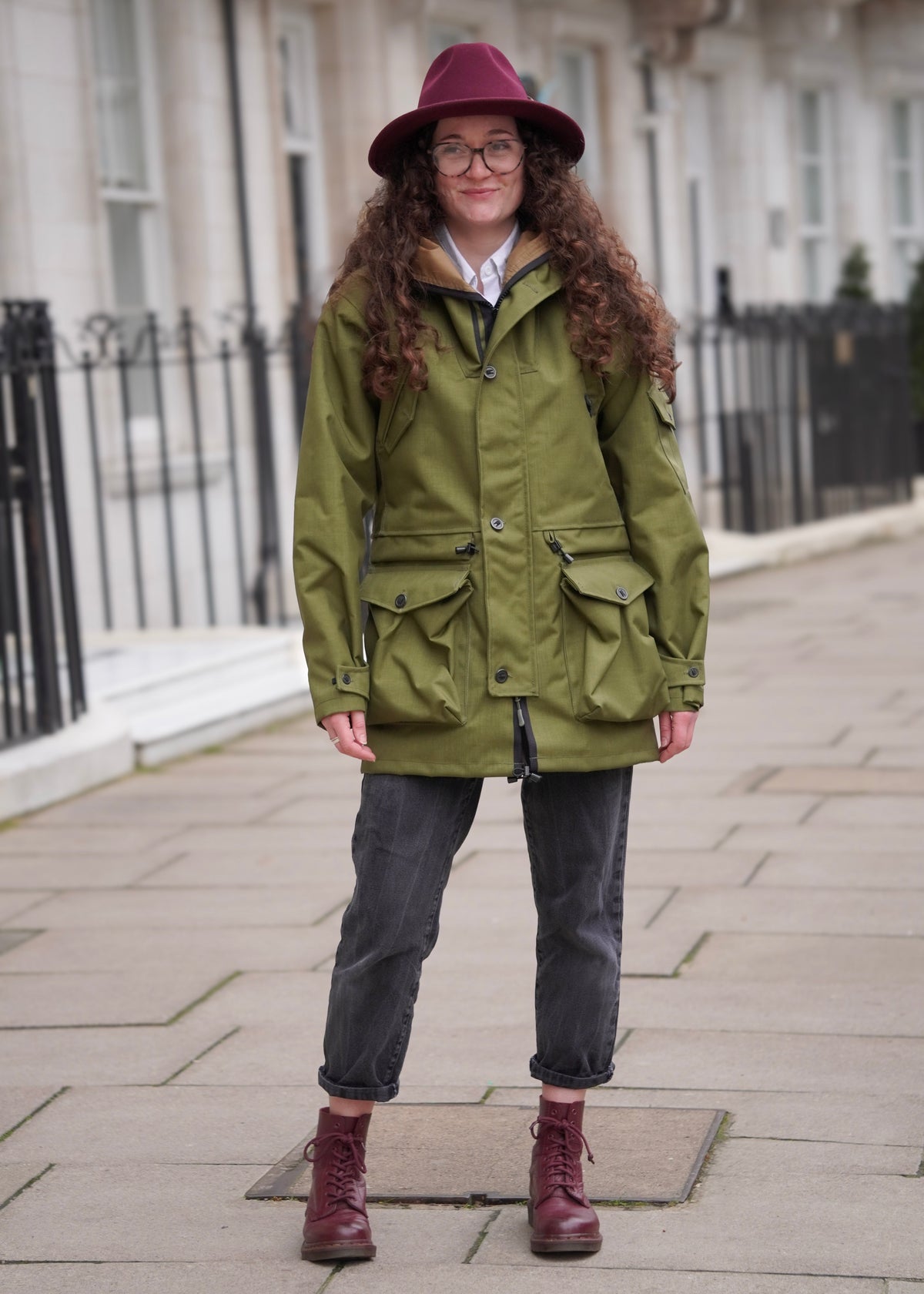 woman wearing a green waterproof jacket in a city centre 