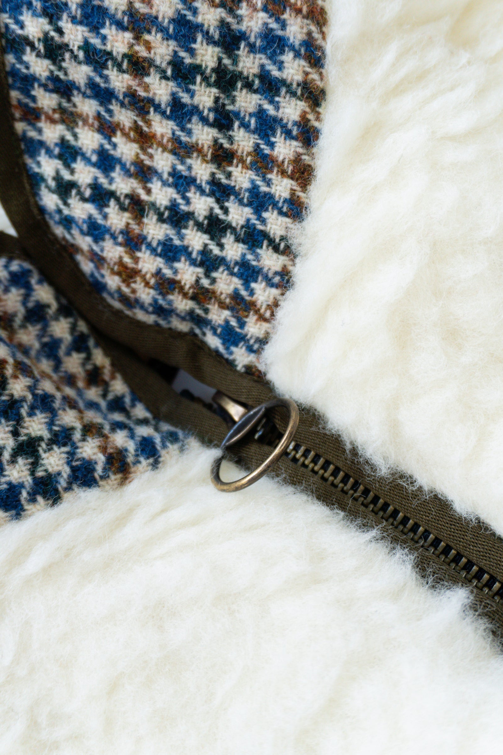 Close-up of a zipper on a checkered fabric with white lining