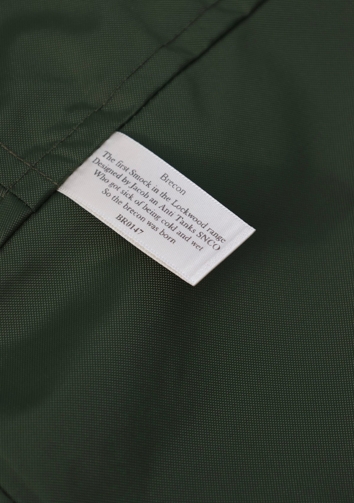 Close-up of a dark green textured fabric with a white sewn-in label reading Brecon.