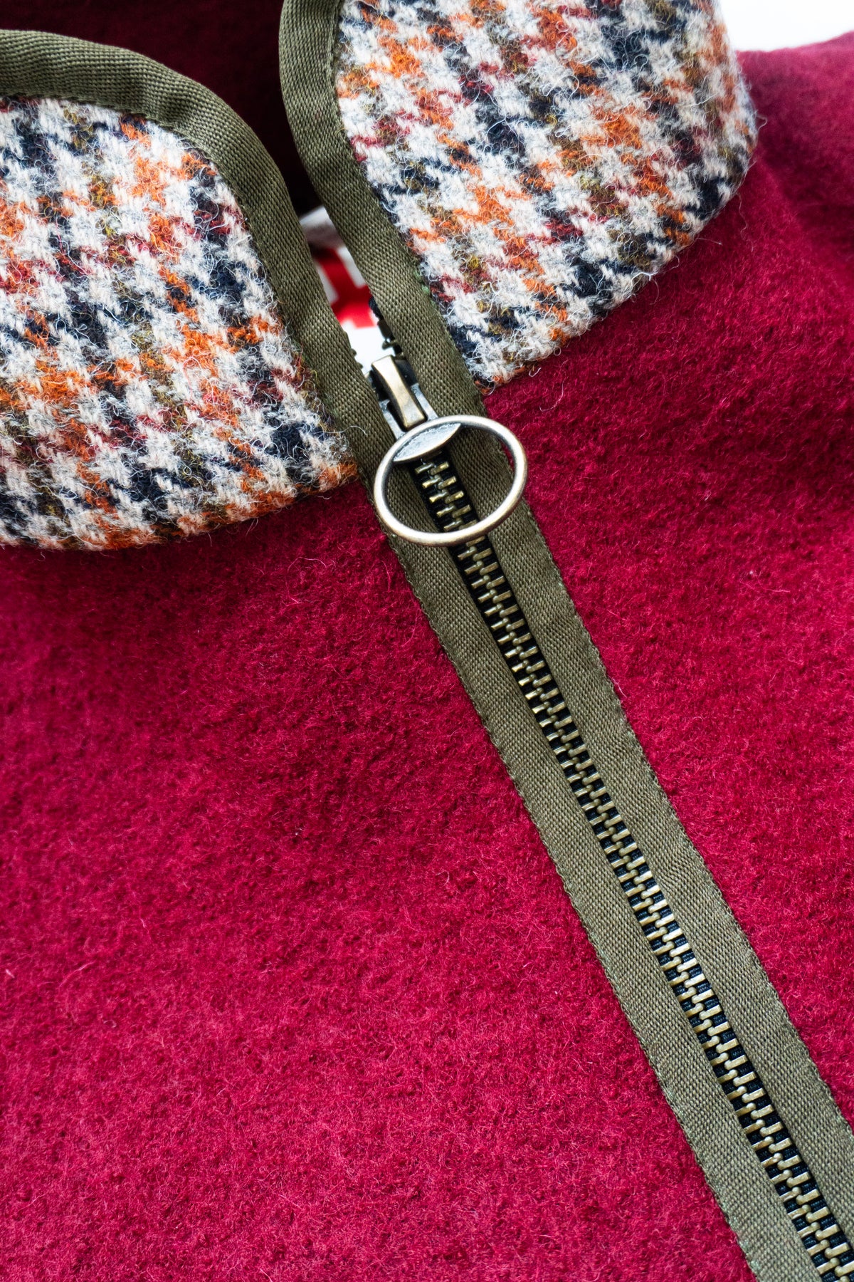 Close-up of a red fleece gilet with a zipper and patterned collar .