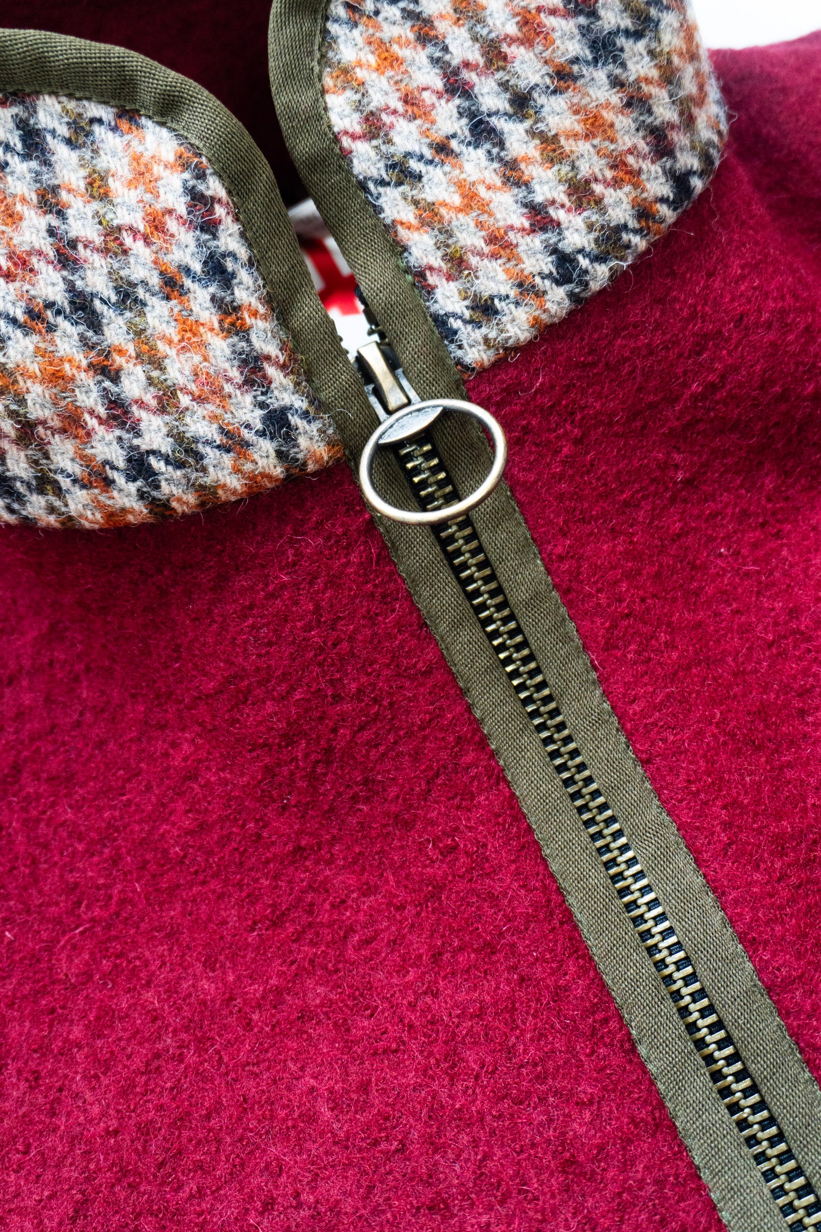 Close-up of a red fleece gilet with a zipper and patterned collar .